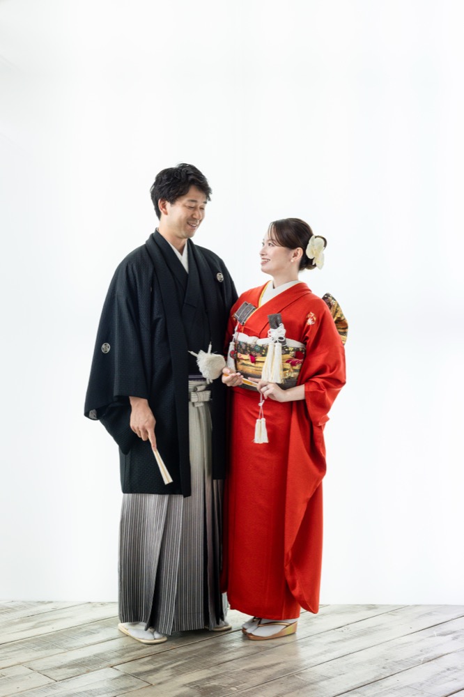 紋付袴の新郎と赤い色打掛の新婦の和装カップル